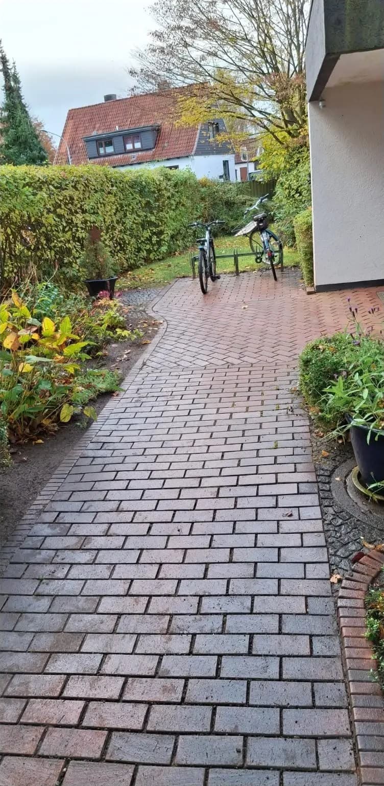 Nachher: derselbe Klinkerweg ohne Laub, frei bis zu den abgestellten Fahrrädern